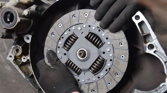 A mechanic installing a new clutch in a car